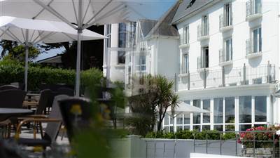 Exterior view of The Garryvoe Hotel with outdoor terrace and balconies