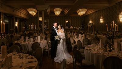 Newly married couple sharing a joyful moment in The Garryvoe Hotel ballroom, beautifully decorated f
