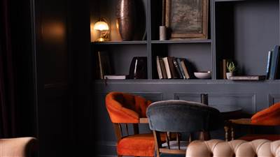 Comfortable library lounge with armchairs, bookshelves and warm lighting