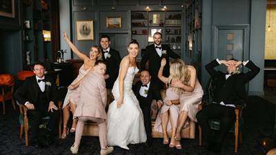 Bride and wedding party celebrating together in the hotel library