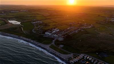 Drone view of The Garryvoe Hotel at sunset, overlooking the golden beach and Ballycotton Bay as the 