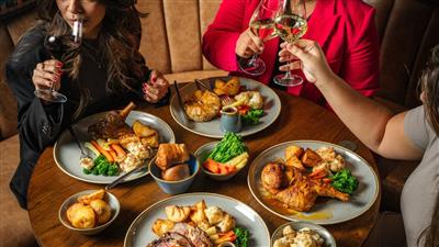 A group of friends sharing dinner and drinks at The London Pub
