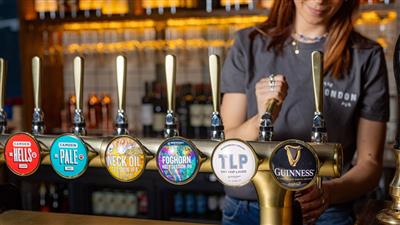 Someone pouring a beer at the bar at The London Pub 