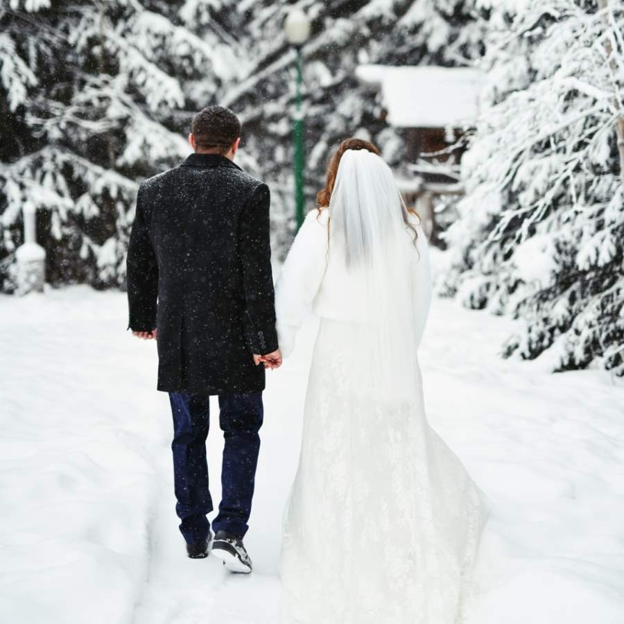 Married couple walking in the forest during snowy day